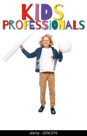 curly boy in costume of architect holding safety helmet and blueprint while jumping near kids professionals lettering on white Stock Photo