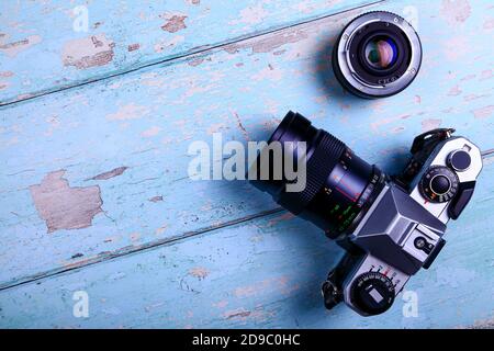 Old vintage film SLR camera and lens sat on a rustic wooden background with space for copy Stock Photo