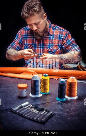 Leather Skinner produce a leatherwork in his work area Stock Photo