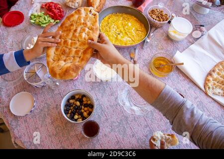 Delicious Turkish  Traditional Breakfast serving on  table ingredients with Egg, Butter,  Olives, Fresh Vegetables, Various Cheese, Bread Pisi, Patty Stock Photo