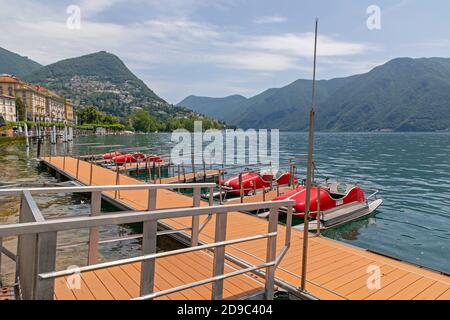 Lugano, Switzerland - June 14, 2019: Red Pedal Boats Rental at Lake in Lugano, Switzerland. Stock Photo