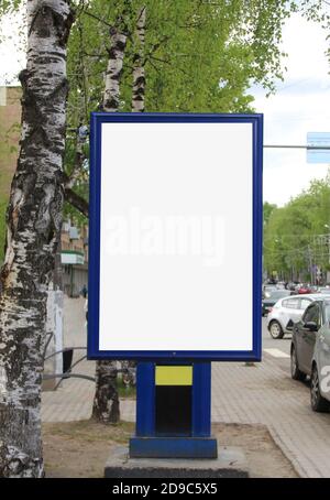 Advertising design with a white vertical rectangular filler. A banner in the city in the summer. A billboard with a place for text and copy space. Stock Photo
