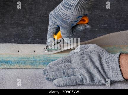 Worker removes upholstery brackets from furniture stapler, shallow depth of field Stock Photo