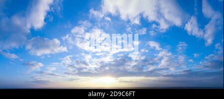 Panorama of bright evening and morning sky, shining sun. Stock Photo