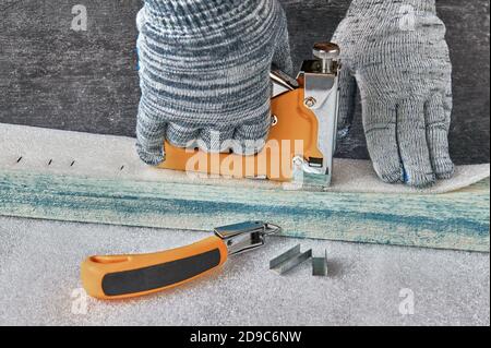 Making wooden furniture.  Joiner works with a furniture stapler, shallow depth of sharpness, close up Stock Photo