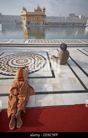 Amritsar, Punjab, India, August 2012 Two Sikh men pray at the Golden Temple. Also known as Sri Harmandir Sahib ('abode of God') is the most sacred Gur Stock Photo