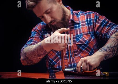 Craftsman working with leather produce a leatherwork Stock Photo