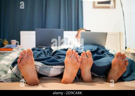 laptop, couple, woman, bed, home, man, bedroom, relationship, together, technology, computer, young, lying, people, love, wife, happy, handsome, inter Stock Photo