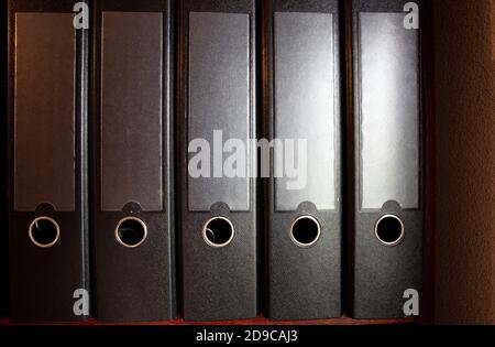four black ring binders on a bookshelf for office or administration, business concept background Stock Photo