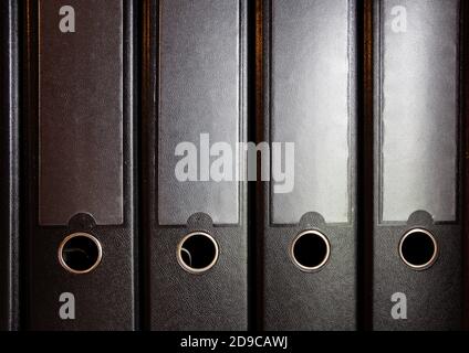 four black ring binders on a bookshelf for office or administration, business concept background Stock Photo