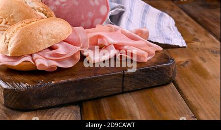 Mortadella and bread. Traditional Italian food for a pre-dinner starter in the restaurant. Typical food Emilia Romagna and the city of Bologna. High quality photo. Banner . Copy space Stock Photo