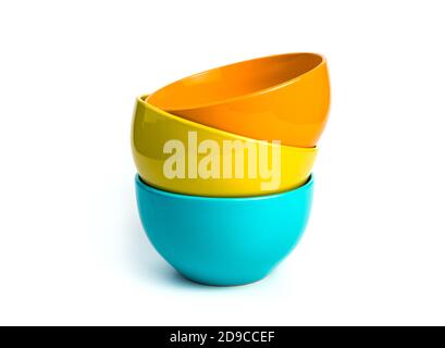 Three bowls of different colors are stacked together on a white Stock Photo
