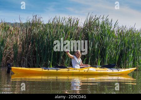 Pchelina, Bulgaria - Oct 3 2020: a woman is taking selfie while kayaking in Pchelina dam Stock Photo