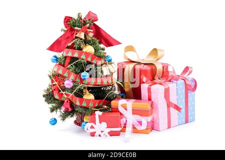 Christmas, New Year concept. A pile of cutely wrapped gifts next to a miniature Christmas tee, isolated on white background. Stock Photo