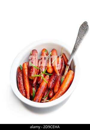 Grilled  baby carrots with honey sauce and green herbs isolated on white Stock Photo