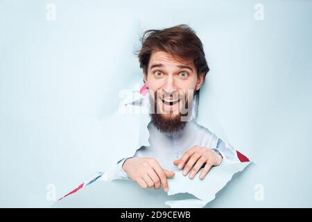 Emotional man stretches his hand forward looking through the wall of emotions office Stock Photo