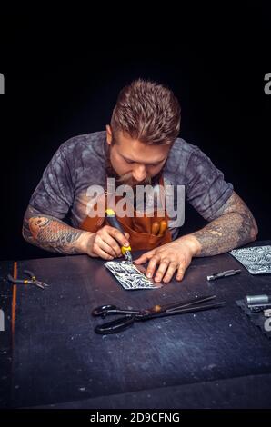 Professional Tanner creating leatherwork in his workshop Stock Photo