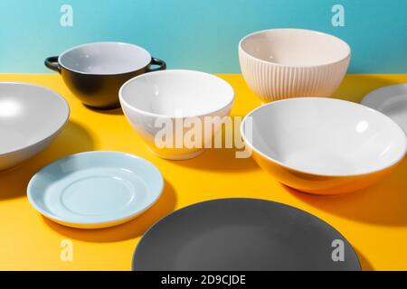 Assorted plates and bowls on yellow table Stock Photo