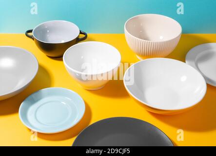 Set of different plates and bowl on bright background Stock Photo