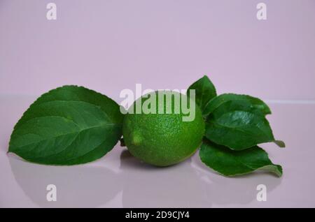 lime juice with lime leaves on pink table. Detox diet. top view. copy space. three limes Stock Photo