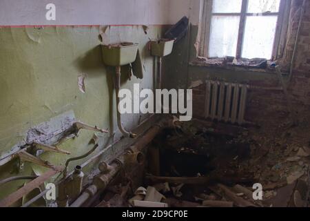 A collapsed floor in a kindergarten toilet in the Chernobyl exclusion zone. Abandoned, dilapidated building. Stock Photo