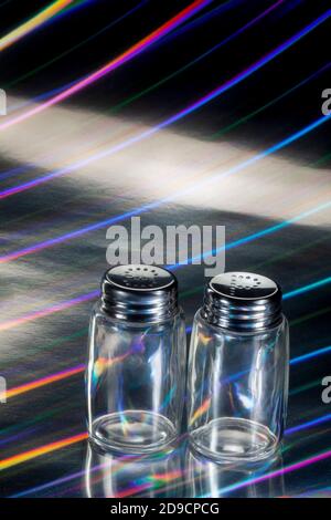 Photo of Empty Salt and Pepper Bottles on Rainbow Stripes Background Stock Photo