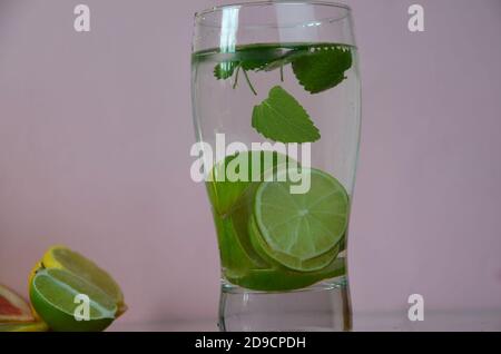 Fresh cocktail drinks with ice fruit and herb mint decoration. Alcoholic non-alcoholic drink-beverage. Mojito on pink background. top wiev copy space Stock Photo