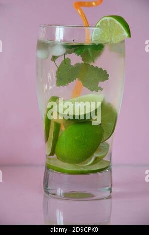 Fresh cocktail drinks with ice fruit and herb mint decoration. Alcoholic non-alcoholic drink-beverage. Mojito on pink background. top wiev copy space Stock Photo