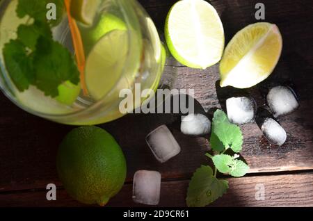 Refreshing mint cocktail mojito with rum and lime, cold drink or beverage with ice on black background, top view Stock Photo