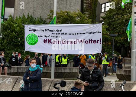 Gottingen, Germany. Autumn 2020. Fridays for future. People sitting near banner at protest against climate change. Medium shot. Stock Photo