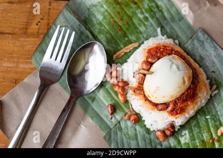 Simple authentic nasi lemak wrapped in banana leaf for breakfast Stock Photo