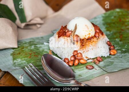 Simple authentic nasi lemak wrapped in banana leaf for breakfast Stock Photo