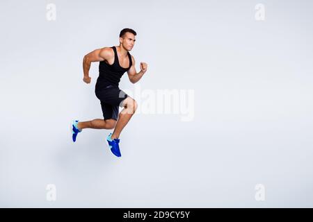 Full length body size view of his he nice attractive muscular focused purposeful guy jumping running jogging sprint distance isolated over light gray Stock Photo