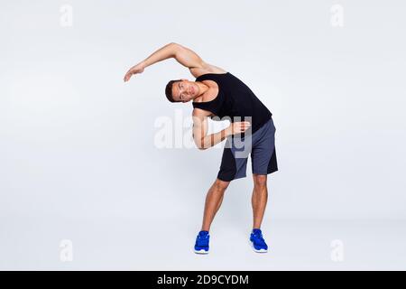 Full length body size view of his he nice attractive focused sportive guy doing inclines stretching pilates isolated over light gray pastel color Stock Photo