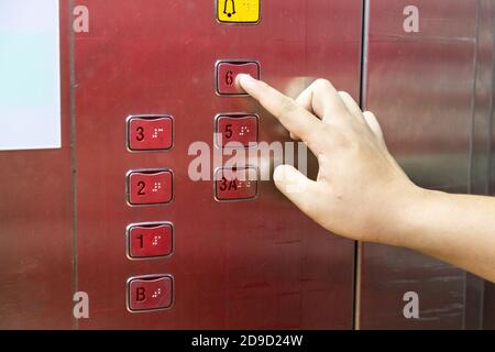 Blind person finger reading braille on elevator lift panel Stock Photo