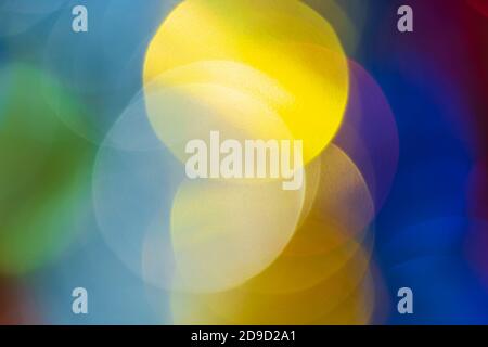 Christmas ornament decorations, vivid defocused abstract blurry bokeh background green, yellow, blue color. Out of focus glowing lights, celebration Stock Photo