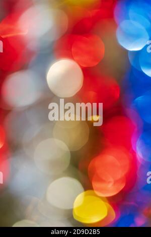 Defocused glowing lights, colorful abstract blurry bokeh background, vivid motion blur texture. Out of focus shining lens flare photo effect Stock Photo