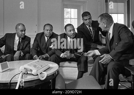 President Lyndon B. Johnson meets with civil rights leaders in the Oval Office of the White House in January 1964. From left, Roy Wilkins, executive director of the NAACP; James Farmer, national director of the Congress of Racial Equality; Martin Luther King, Jr., president of the Southern Christian Leadership Conference; and Whitney Young, executive director of the National Urban League. Stock Photo