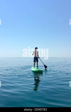 Sup board. water sport. a young man stands on a board in the sea Stock Photo