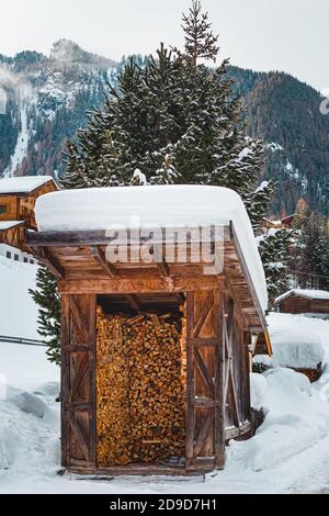 snow covered traditional firewood hut in St. Gertraud (Ultental,South Tyrol/Italy) on cold winter day Stock Photo