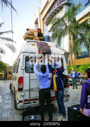 12/1/2018 Indian driver loading bags to a luggage carrier on the van roofs to have more space for passengers in the car