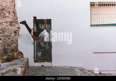 young sportsman practicing parkour, acrobatics and deadly jumps in the streets of the city Stock Photo
