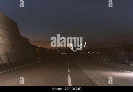 young sportsman practicing parkour, acrobatics and deadly jumps in the streets of the city Stock Photo