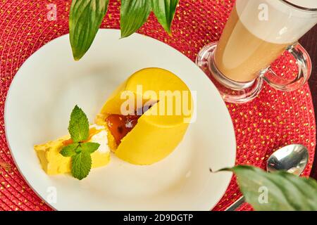 Yellow mini cake covered with yellow glaze on table in cafe close up Stock Photo