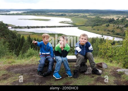 Children sitting on bench On Mount Paaso in summer, Karelia Stock Photo