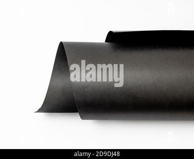 Rolled black art paper isolated on white background Stock Photo