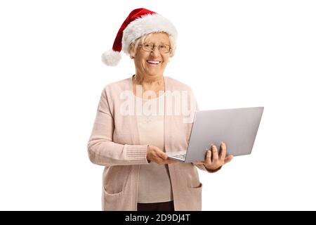 Happy elderly woman holding a laptop computer and wearing a santa claus hat isolated on white background Stock Photo