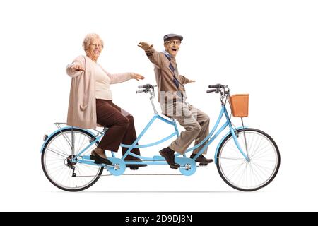 Elderly man and woman riding a blue tandem bicycle and spreading their arms isolated on white background Stock Photo