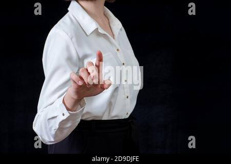 Businesswoman in front of visual touchscreen, isolated on black background. Business concept. Online learning Stock Photo