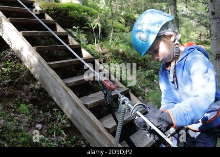 Child using carabiner on training route to rope park, Karelia Stock Photo